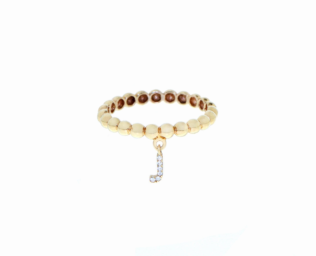 Yellow gold beaded ring with a small diamond letter pendant