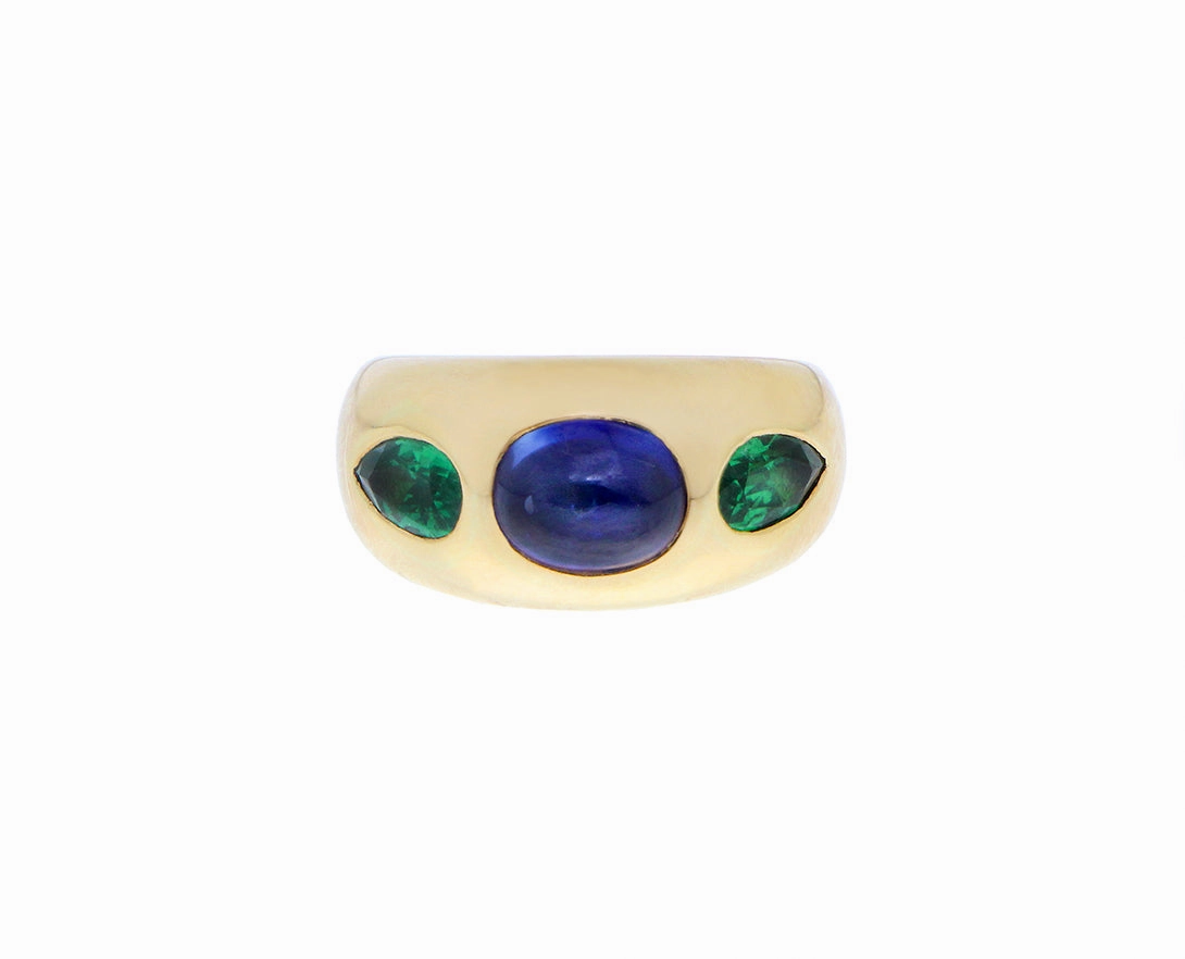 Yellow gold gypsy ring with a cabochon cut sapphire and tsavorites